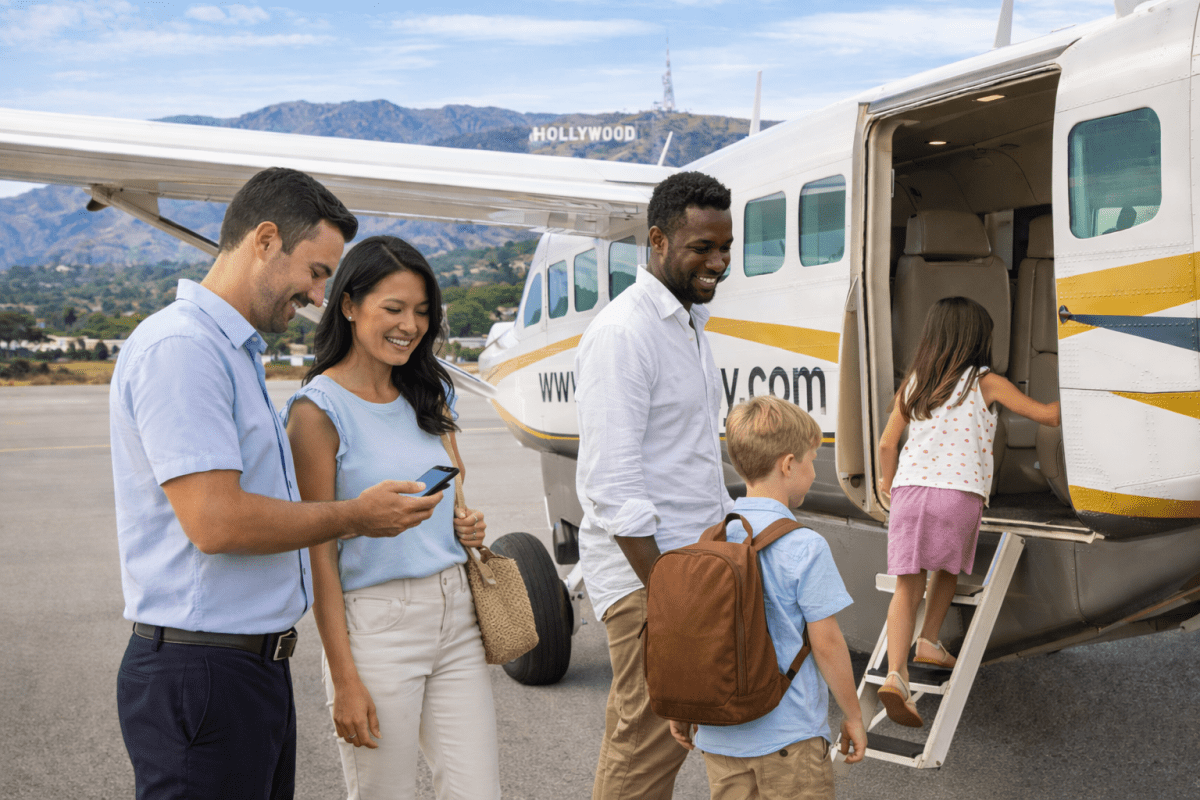 Smiling group with children boarding a small plane on a sunny day, Hollywood sign in the background.